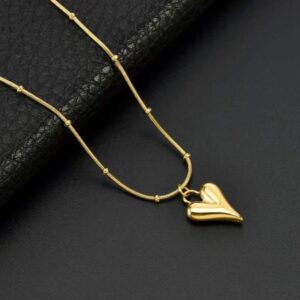 A studio shot of an Eternal Heart Charm Necklace resting on a dark texture