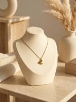 A woman wearing a delicate gold plated heart necklace