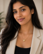 A delicate gold plated heart necklace on a black velvet display