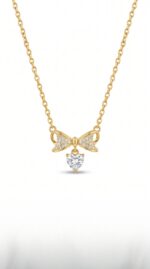 Model wearing delicate bow and heart necklace