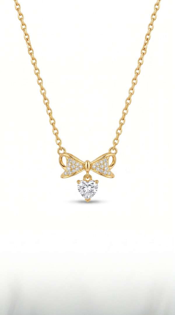 Model wearing delicate bow and heart necklace
