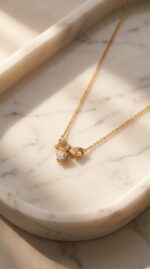 Close up of gold plated heart necklace with bow charm
