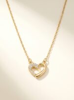 Close up of dainty gold plated heart necklace with clear stones