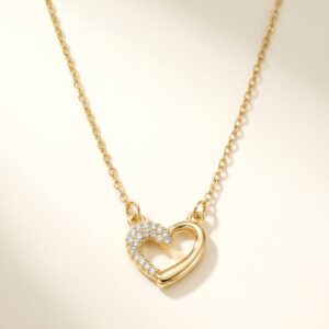 Close up of dainty gold plated heart necklace with clear stones