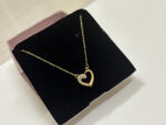 Elegant gold plated heart necklace on white surface