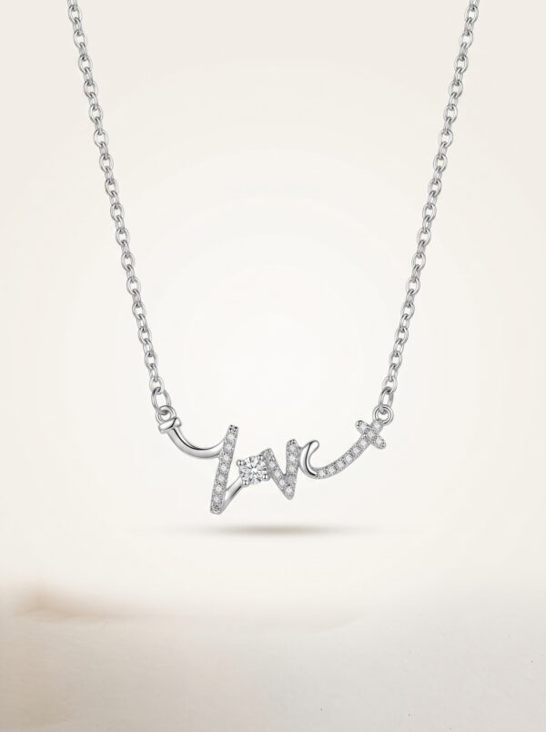 Silver love script necklace on white background