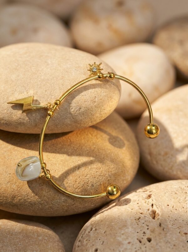 woman wearing a gold plated bracelet with celestial charms