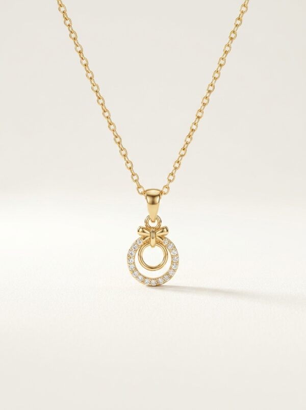 Close up of the gold plated necklace with a circular pendant on a black stand