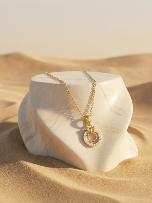Close up of the gold plated necklace with a circular pendant on a black stand