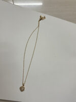 Close up of gold plated pendant with stone detailing on black velvet box