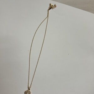Close up of gold plated pendant with stone detailing on black velvet box