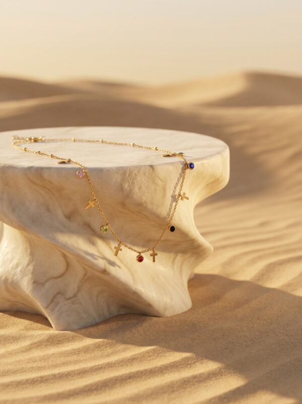 Elegant gold plated necklace featuring cross motifs on a desert marble pedestal