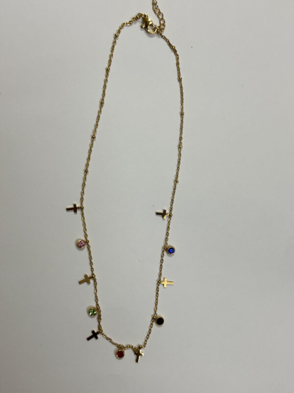 Multi-colored gem and cross charm gold plated necklace on display