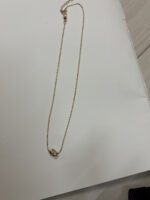 Minimalist gold plated necklace on black velvet display