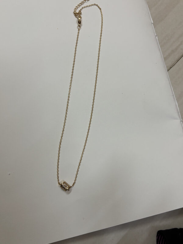 Minimalist gold plated necklace on black velvet display