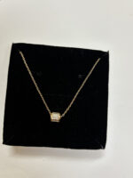Woman wearing gold plated necklace showing cylinder pendant