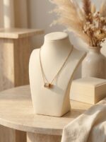 Close up of gold plated necklace with cylinder pendant