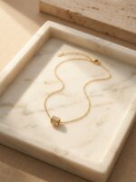 Close up of gold plated necklace with cylinder pendant