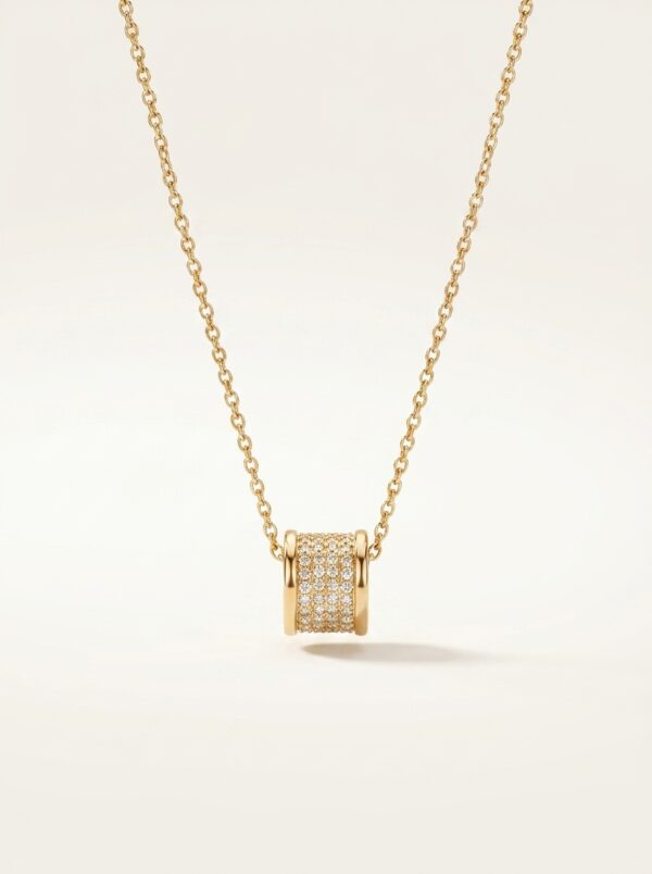 Close up of gold plated necklace with cylinder pendant