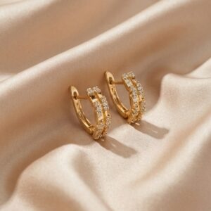 Pair of gold plated hoop earrings resting on satin silk