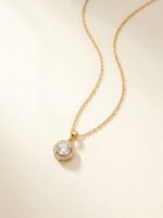 Close up of gold plated heart necklace with central stone