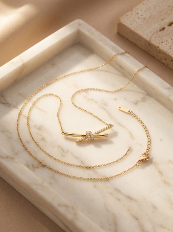 Aura Knot Golden Necklace laid flat on white surface