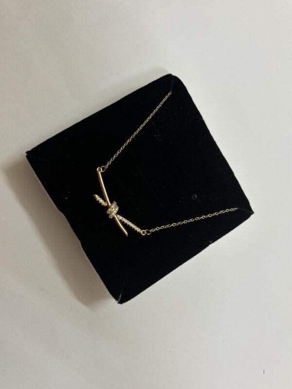 Aura Knot Golden Necklace laid flat on white surface