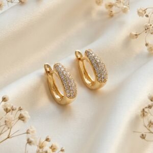 Close up of gold Pavé Hoop Earrings on silk