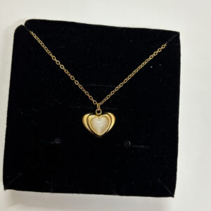 Woman wearing a delicate gold plated heart necklace with mother of pearl inlay