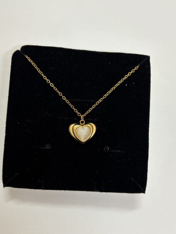 Woman wearing a delicate gold plated heart necklace with mother of pearl inlay
