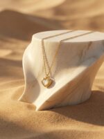 Gold plated heart necklace with mother of pearl center on black jewelry box