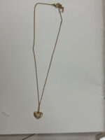 Gold plated heart necklace with mother of pearl center on black jewelry box