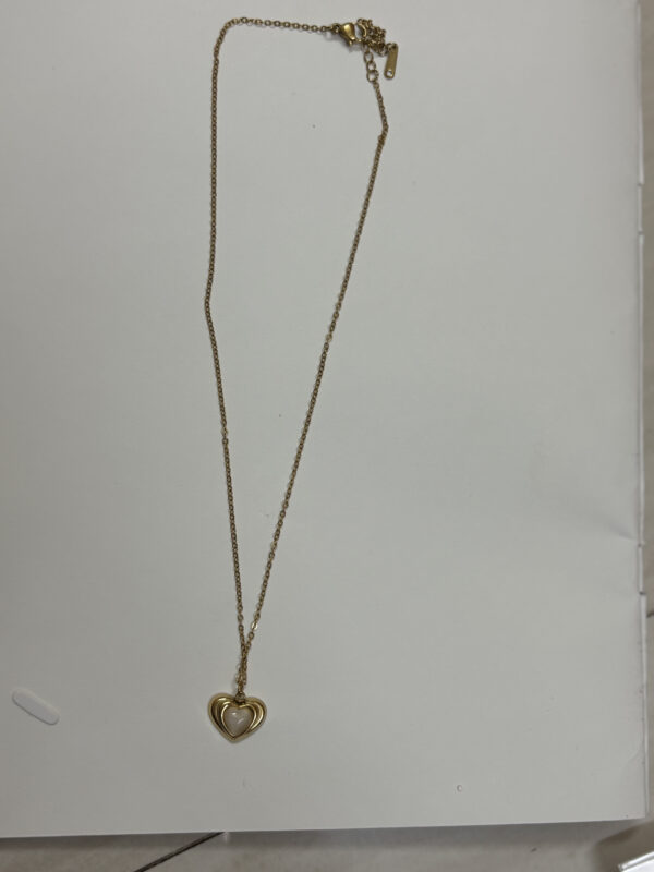 Gold plated heart necklace with mother of pearl center on black jewelry box