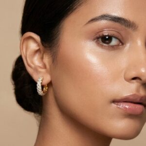 Close up of model wearing sparkling gold pave hoop earrings