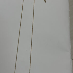 Close up of the Crescent Moon Golden Necklace resting on a black velvet display