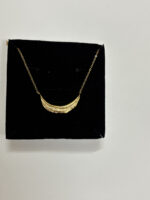A woman wearing the delicate Crescent Moon Golden Necklace with a crisp white shirt
