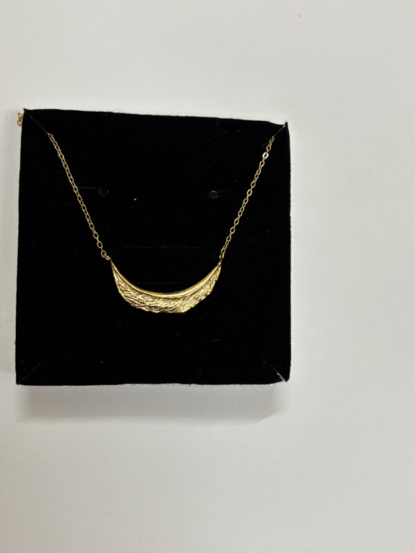A woman wearing the delicate Crescent Moon Golden Necklace with a crisp white shirt