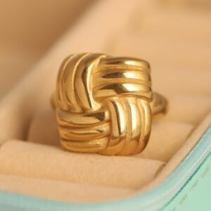 Elegant gold plated knot ring with ribbed texture in a teal jewelry box