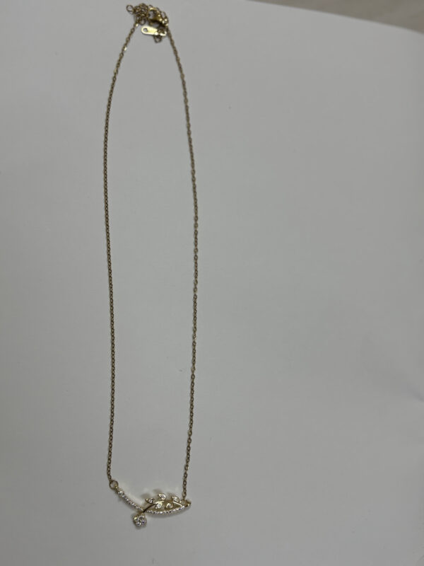 Close up of floral leaf necklace on black velvet display