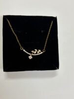 Elegant gold plated necklace on emerald green silk