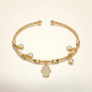 The Hamsa Protection Golden Bracelet resting on natural river stones
