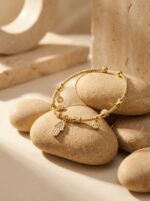 A model wearing the delicate Hamsa Protection Golden Bracelet on her wrist