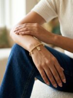 Close up of the Hamsa Protection Golden Bracelet on a cream background