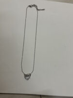 Studio shot of the Intertwined Heart Necklace on a soft cream background
