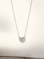 Flat lay of the Intertwined Heart Necklace on a white surface