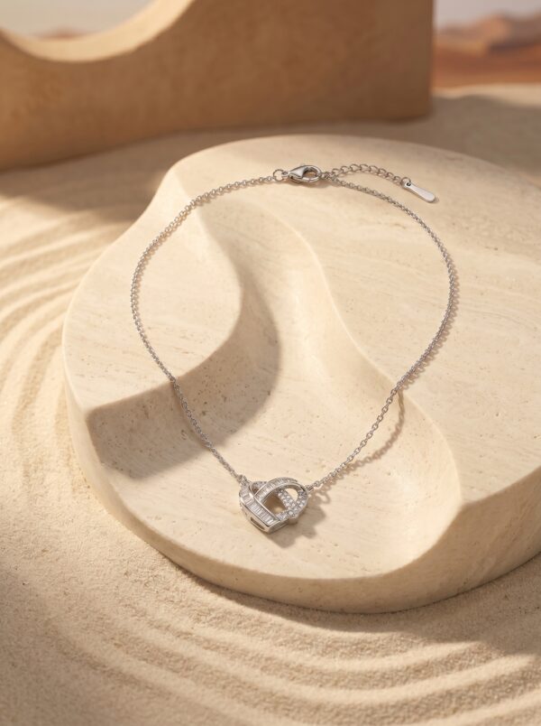 Flat lay of the Intertwined Heart Necklace on a white surface