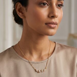 A delicate gold plated necklace featuring a leaf motif with sparkling marquise stones