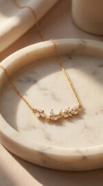 A delicate gold plated necklace featuring a leaf motif with sparkling marquise stones