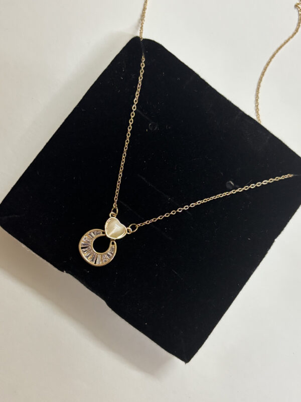 Full view of dainty gold heart pendant necklace on white background