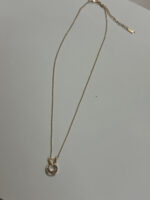 Studio shot of Lumina gold heart pendant necklace on marble stone